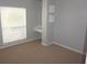 Bright bedroom includes carpet, a large window, and a built-in vanity with shelving at 8025 Old Town Dr, Orlando, FL 32819