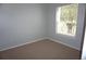 Cozy bedroom with light blue walls and carpet, complemented by a window with natural light at 8025 Old Town Dr, Orlando, FL 32819