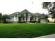 Inviting single-Gathering home with lush green lawn, palm trees, and a classic architectural style at 8025 Old Town Dr, Orlando, FL 32819