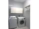 Laundry room has a washer, dryer, storage cabinets, and tile flooring at 8025 Old Town Dr, Orlando, FL 32819