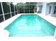 Sparkling in-ground pool with screened enclosure, surrounded by a white concrete patio at 8025 Old Town Dr, Orlando, FL 32819