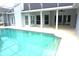 In-ground pool is enclosed and features a sun shelf and steps for easy access at 8025 Old Town Dr, Orlando, FL 32819