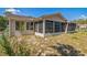 The back exterior has a screened-in porch, vinyl siding and a well-manicured lawn at 8426 Sw 114Th St, Ocala, FL 34481