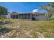 The back exterior has a screened-in porch, vinyl siding and a well-manicured lawn at 8426 Sw 114Th St, Ocala, FL 34481