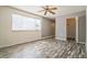 A bedroom featuring wood floors, a ceiling fan, and a large window providing natural light at 8426 Sw 114Th St, Ocala, FL 34481