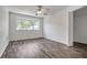 Bedroom showcasing wood floors, ceiling fan, large window, and an adjacent closet at 8426 Sw 114Th St, Ocala, FL 34481