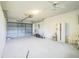 A spacious garage with a lawnmower, overhead door, and ample storage at 8426 Sw 114Th St, Ocala, FL 34481