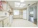 Bright kitchen featuring white cabinetry, appliances, tiled floors, and a skylight at 8426 Sw 114Th St, Ocala, FL 34481