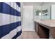 Modern bathroom features a sleek vanity, decorative mirror, and blue striped shower curtain at 936 Calabria Ave, Davenport, FL 33897