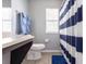Bright bathroom features a blue and white striped shower curtain and modern gray walls at 936 Calabria Ave, Davenport, FL 33897