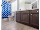 Bathroom featuring a blue and white curtained shower, toilet and sleek dark vanity at 936 Calabria Ave, Davenport, FL 33897