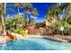Resort-style pool features a slide, waterfall, lush landscaping, and inviting clear blue water at 936 Calabria Ave, Davenport, FL 33897