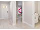 Bright hallway features tile flooring, white walls, and view to the front door and flag draped in adjacent room at 999 Trumbull St, Deltona, FL 32725