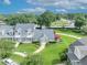 Aerial view of a meticulously landscaped home with mature trees and a vibrant red porch awning at 104 Nautica Mile Dr, Clermont, FL 34711