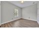 Neutral bedroom features a large window providing ample natural light, complemented by wood-look flooring at 104 Nautica Mile Dr, Clermont, FL 34711