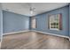 Bedroom with hardwood floors, light blue walls, a ceiling fan, and multiple windows at 104 Nautica Mile Dr, Clermont, FL 34711