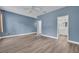 Bedroom with hardwood floors, light blue walls, access to a bathroom, and a ceiling fan at 104 Nautica Mile Dr, Clermont, FL 34711