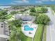 Aerial view showcases a community pool and clubhouse surrounded by lush greenery and nearby housing at 104 Nautica Mile Dr, Clermont, FL 34711