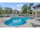 Community pool area with inviting blue water, surrounding lounge chairs and lush greenery at 104 Nautica Mile Dr, Clermont, FL 34711