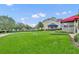 Scenic view of the home's exterior with expansive lawn and adjacent building with a blue awning at 104 Nautica Mile Dr, Clermont, FL 34711