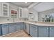 A corner kitchen with stainless steel appliances, white counters, and two-tone blue cabinets at 104 Nautica Mile Dr, Clermont, FL 34711