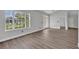 Light-filled living room with light wood-look floors and large window with a view of greenery at 104 Nautica Mile Dr, Clermont, FL 34711