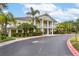 Yellow multi-story clubhouse featuring white columns and beautiful landscaping at 110 Watling Way # 25204, Davenport, FL 33837