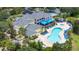 Aerial view of community pool, lounge chairs, hot tub, and clubhouse with lush landscaping at 110 Watling Way # 25204, Davenport, FL 33837