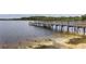 Wooden dock extending into a tranquil lake under a cloudy sky at 110 Watling Way # 25204, Davenport, FL 33837