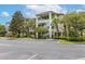 A beautiful exterior view of a green and white apartment building with palm trees and parking at 110 Watling Way # 25204, Davenport, FL 33837