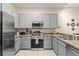 Well-equipped kitchen featuring gray cabinets, modern appliances, and ample countertop space at 110 Watling Way # 25204, Davenport, FL 33837