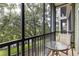 Relaxing screened patio with a table and chairs overlooking a lush green space and pond at 110 Watling Way # 25204, Davenport, FL 33837