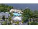 Aerial view of a community pool with beach, dock, and tiki bar on the lake at 110 Watling Way # 25204, Davenport, FL 33837
