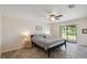 Cozy bedroom featuring a ceiling fan, tile floors, and a sliding glass door to the backyard at 11412 Stamfield Dr, Orlando, FL 32821