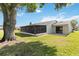 Back exterior view of the house showing the lanai, yard, and surrounding landscape at 11412 Stamfield Dr, Orlando, FL 32821
