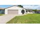Charming single-story home featuring a well-kept lawn, a two-car garage, and an inviting entrance at 11412 Stamfield Dr, Orlando, FL 32821