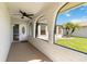 Inviting front porch with a ceiling fan, view of a well-kept lawn and palm trees at 11412 Stamfield Dr, Orlando, FL 32821