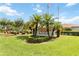 Community entrance sign with lush landscaping and mature palm trees in a well-maintained community at 11412 Stamfield Dr, Orlando, FL 32821