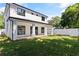 A home backyard shows a covered patio, large green space, white exterior with black trim, and a privacy fence at 1217 Cloverlawn Ave, Orlando, FL 32806