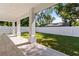 Covered outdoor patio, surrounded by a white fence and green lawn at 1217 Cloverlawn Ave, Orlando, FL 32806
