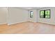 A home bedroom shows light hardwood floors, neutral colored walls, white trim, and windows with black trim at 1217 Cloverlawn Ave, Orlando, FL 32806