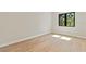 A home bedroom shows light hardwood floors, neutral colored walls, and a window with black trim at 1217 Cloverlawn Ave, Orlando, FL 32806