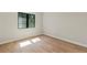 A home bedroom shows light hardwood floors, neutral colored walls, and a window with black trim at 1217 Cloverlawn Ave, Orlando, FL 32806