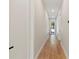 Inviting hallway featuring gleaming hardwood floors, leading to a bright front door at 1217 Cloverlawn Ave, Orlando, FL 32806