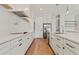 A modern kitchen features white cabinets and countertops, stainless steel appliances, and hardwood floors at 1217 Cloverlawn Ave, Orlando, FL 32806
