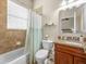 Neutral bathroom with a vanity with granite top, tiled shower, and window at 1319 Johns Cove Ln, Oakland, FL 34787