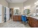 Bathroom with dual vanities, granite countertops, and decorative mirrors at 1319 Johns Cove Ln, Oakland, FL 34787