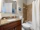 Cozy bathroom with granite vanity, tiled shower, and neutral decor at 1319 Johns Cove Ln, Oakland, FL 34787