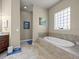 Bright bathroom featuring a sunken tub with tile surround and a glass block window at 1319 Johns Cove Ln, Oakland, FL 34787