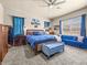 Comfortable bedroom featuring blue accents, carpeted floors, a ceiling fan, and natural light at 1319 Johns Cove Ln, Oakland, FL 34787